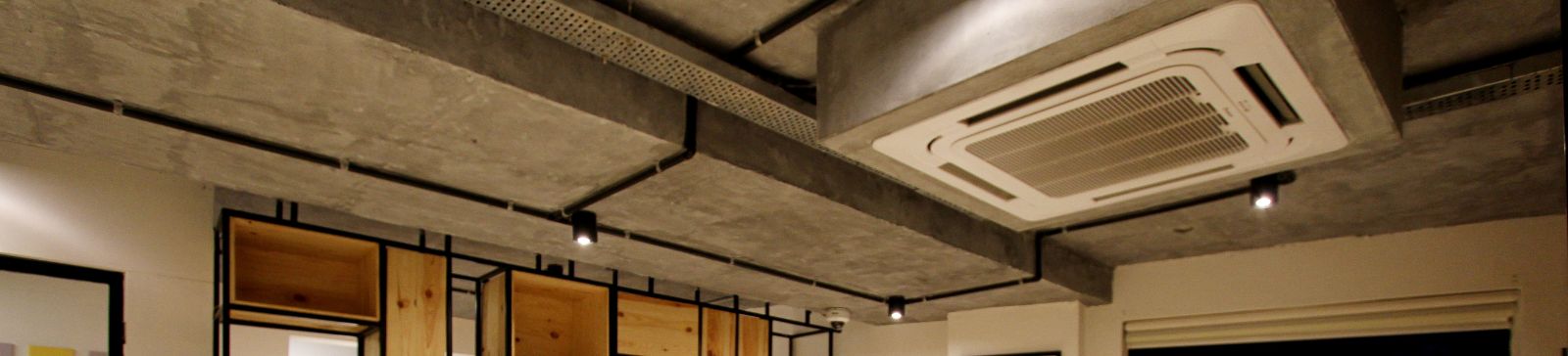 A view at an empty living room with huge HVAC on the ceiling