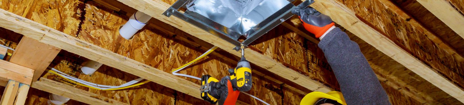 A male technician mounted air conditioner on ceiling ventilation