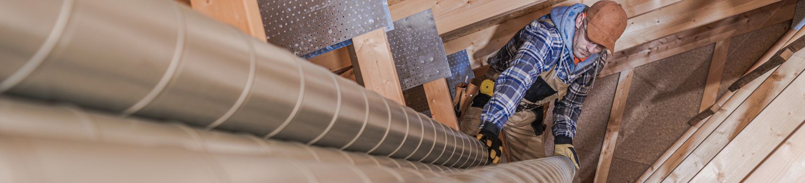 A tech preparing air vent pipes for installation